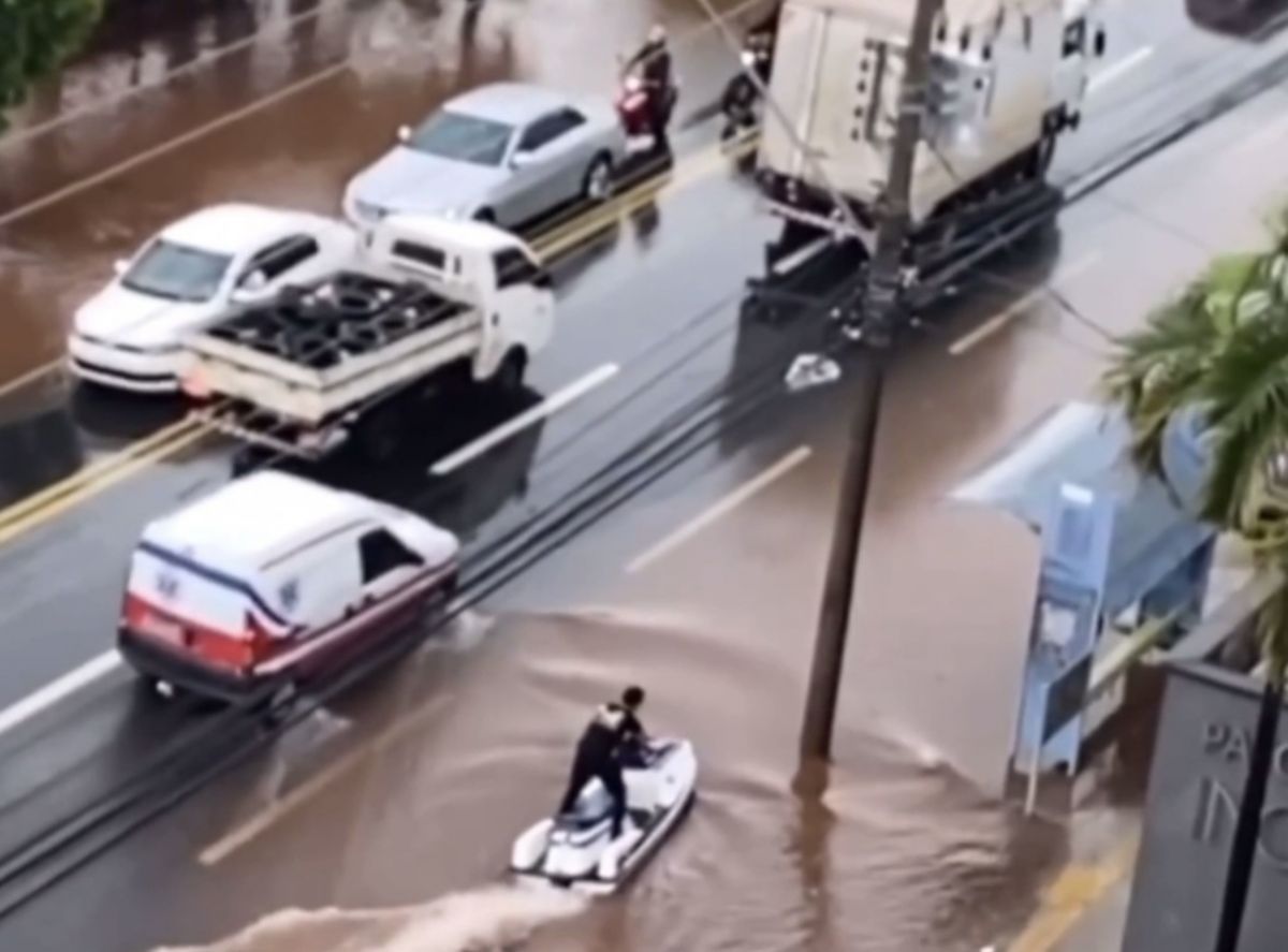 Após chuva, homem pilota jet ski em rua de Goiânia